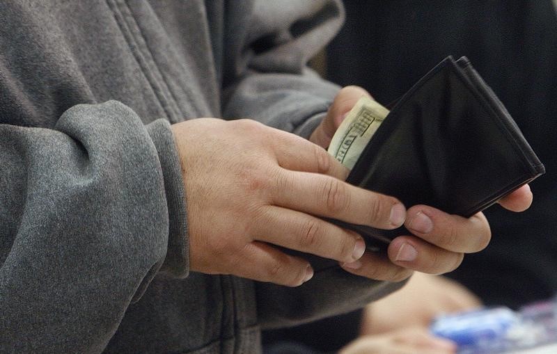 © Reuters. A shopper reaches into his wallet to pay for a purchase on "Black Friday" at the K-Mart store in Burbank, California