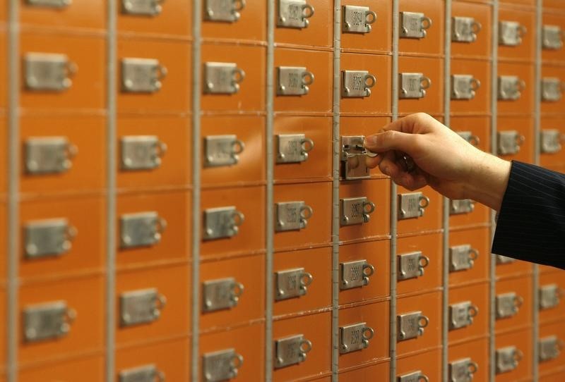 © Reuters. An employee checks a safe box in the vault of a Swiss bank in Basel