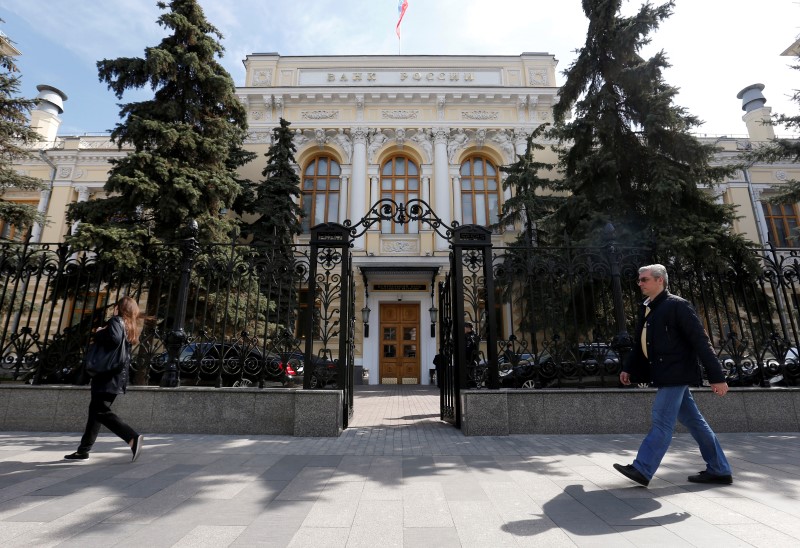 © Reuters. People walk past the Central Bank headquarters in Moscow, Russia