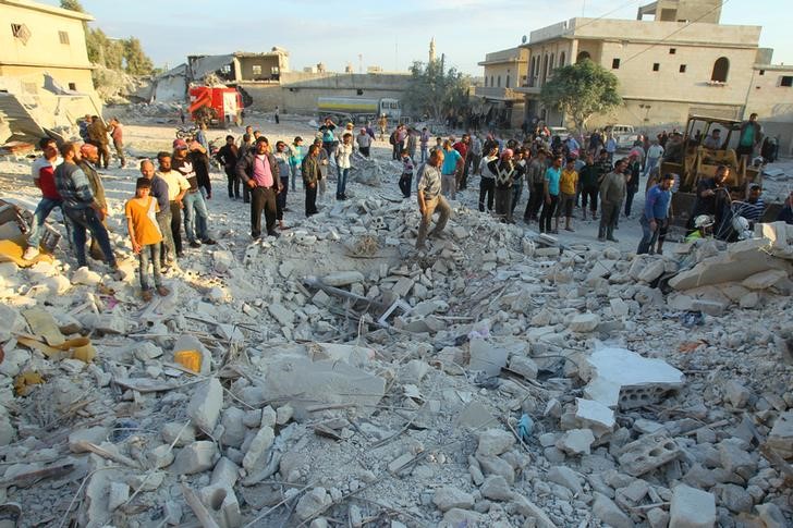 © Reuters. Residents inspect a site damaged by an airstrike in Hafsarja