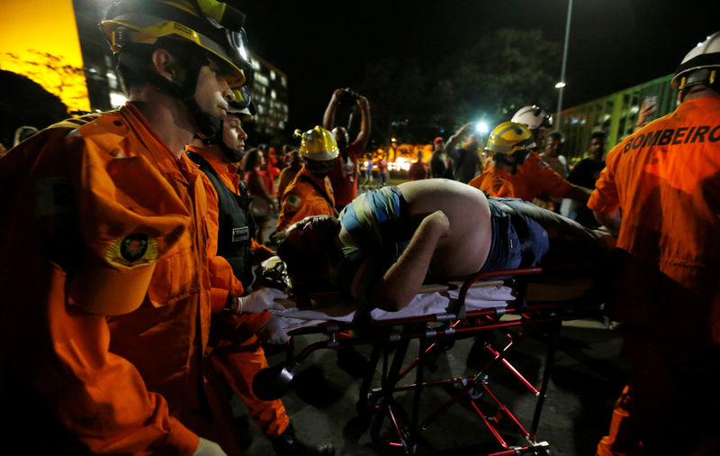 © Reuters. Rescue workers helps an injured demonstrator during a protest against the impeachment of President Rousseff in Brasilia