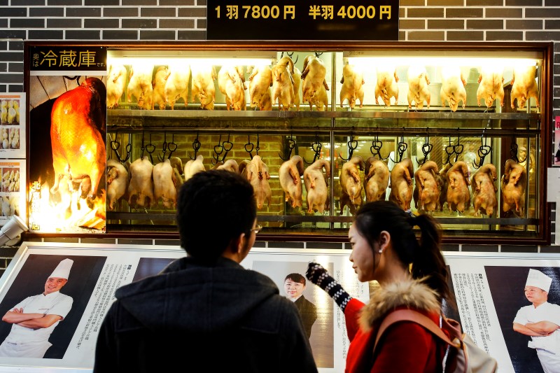 © Reuters. People look at a display of ducks at a restaurant in Chinatown in Yokohama