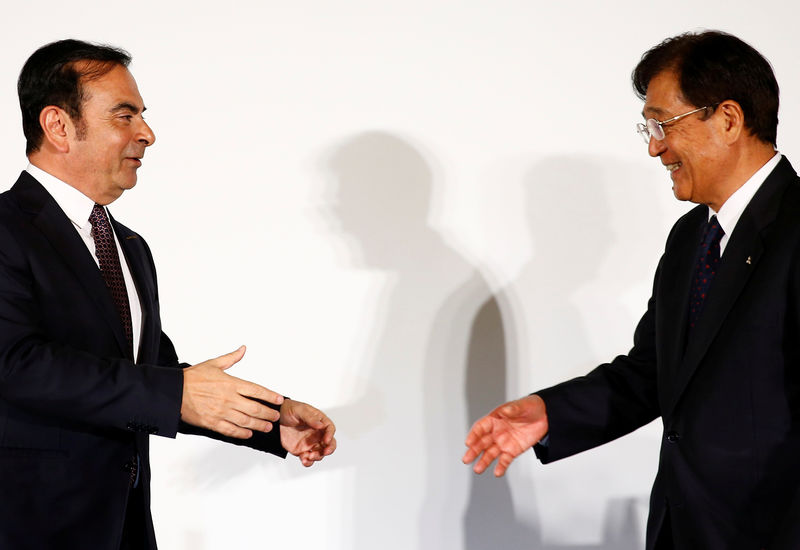 © Reuters. Carlos Ghosn, Chairman and CEO of the Renault-Nissan Alliance, reaches out to shake hands with Mitsubishi Motors Corp.'s Chairman and CEO Osamu Masuko at their joint news conference in Yokohama, Japan