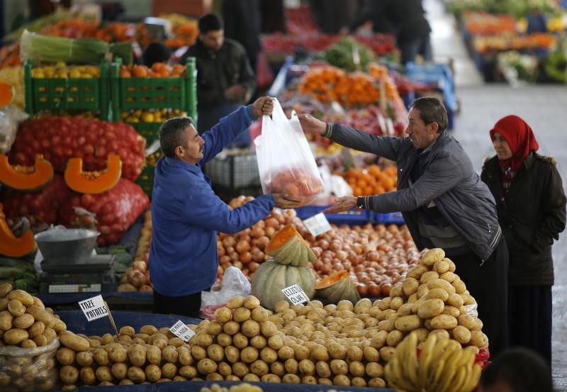 © Reuters. A vendor sells potatoes and other vegetables to a customer in an open market in central Ankara