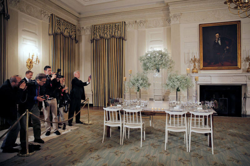 © Reuters. Photojournalists take pictures of set table during the preview of a state dinner where U.S. President Barack Obama will host five leaders of Nordic nations at a lavish state dinner at the White House on Friday, in Washington