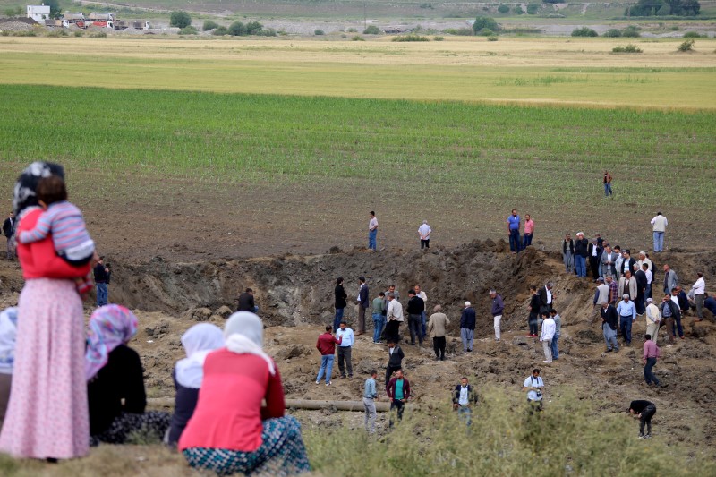 © Reuters. People gather at the site of last night's explosion near the Kurdish-dominated southeastern city of Diyarbakir