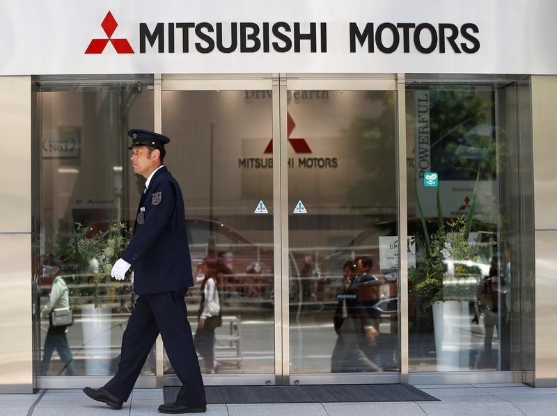 © Reuters. A security personnel walks in front of an entrance of Mitsubishi Motors Corp's headquarters in Tokyo, Japan