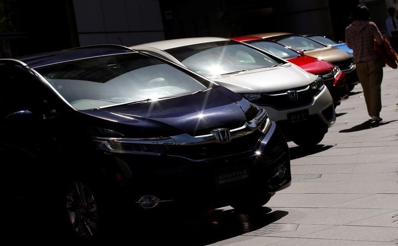 © Reuters. Woman walks past Honda Motor cars outside the company's showroom in Tokyo