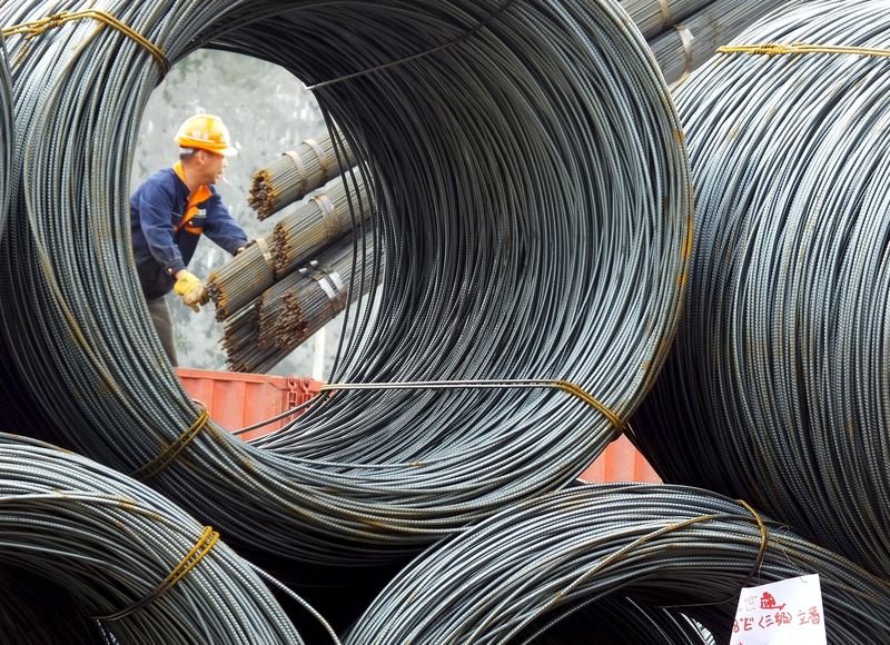 © Reuters. An employee unloads steel products at a market in Yichang