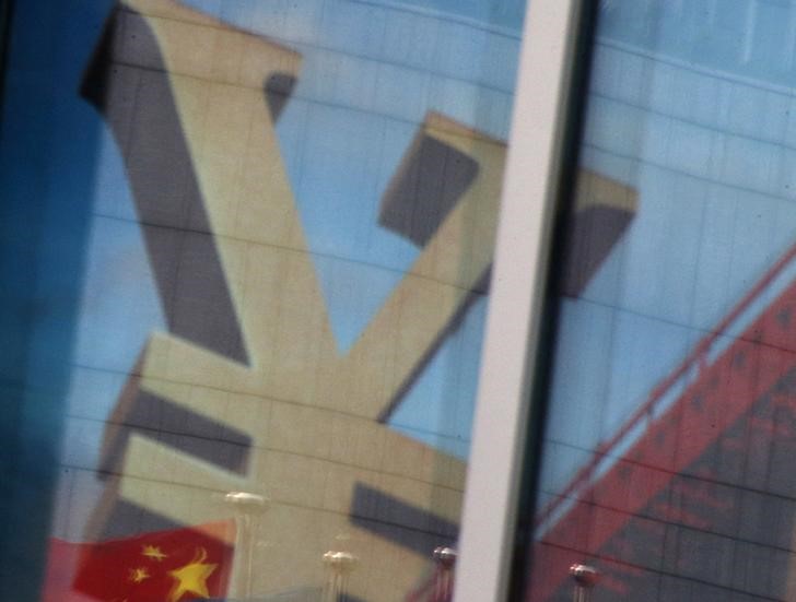 © Reuters. China's national flag is reflected on an advertisement of a commercial bank bearing the sign of Chinese Yuan at a branch of a commercial bank at a business district in Beijing