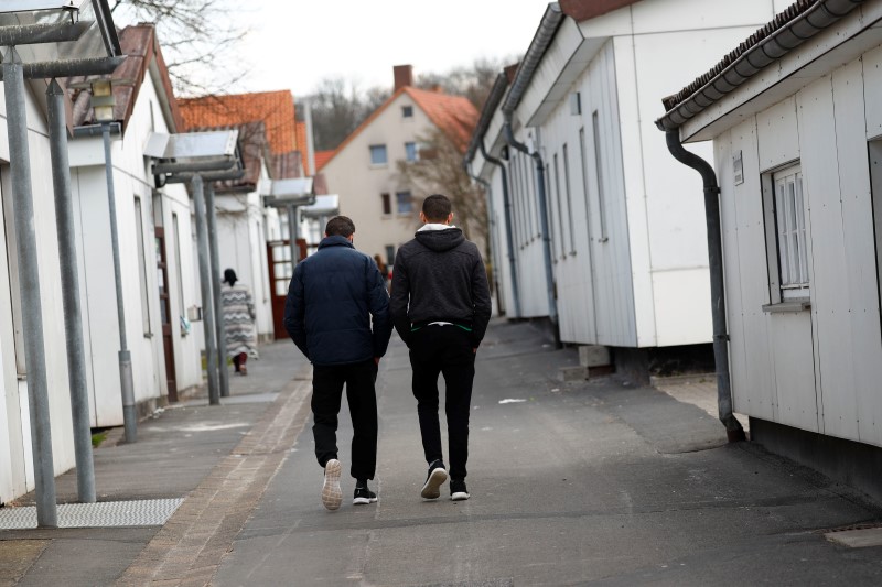 © Reuters. Migrants stroll between barracks at the camp for refugees in Friedland