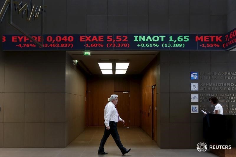 © Reuters. An employee walks under a stock ticker showing stock options inside the Athens stock exchange building in Athens