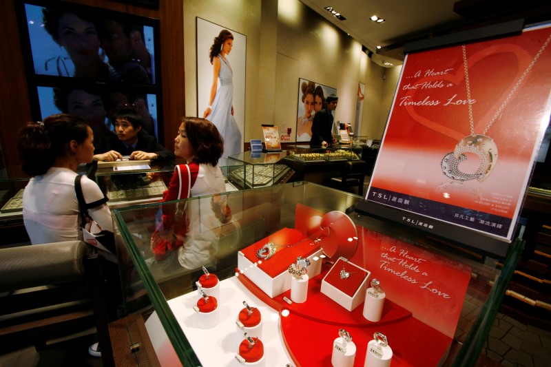 © Reuters. Mainland Chinese visitors sit in a jewellery store promoting gold and platinum accessories for the upcoming Valentine's Day in Hong Kong