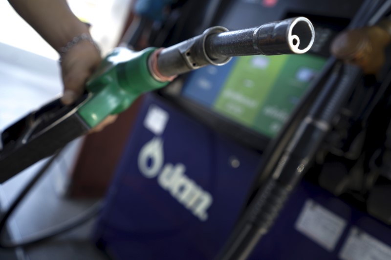 © Reuters. A worker grabs a nozzle at a PTT gas station in Bangkok