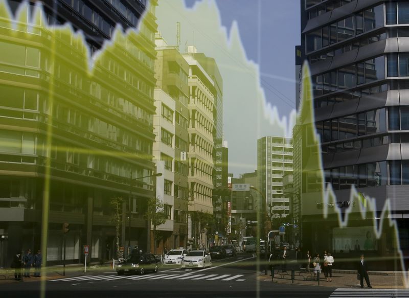 © Reuters. Здание и люди отражаются в электронном табло с графиком колебаний иены