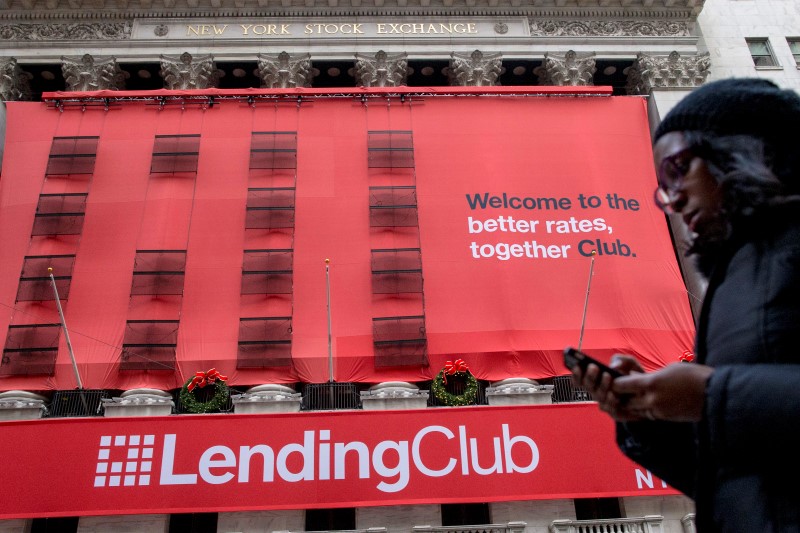 © Reuters. A woman looks at her phone as she passes by a Lending Club banner on the facade of the the New York Stock Exchange