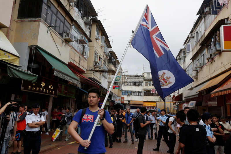 © Reuters. A local protester against mainland Chinese parallel traders carries a British Hong Kong colonial flag in Hong Kong