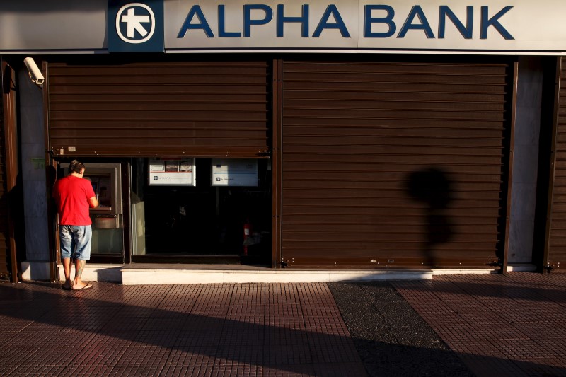 © Reuters. A man withdraws money at an Alpha Bank branch ATM in central Athens