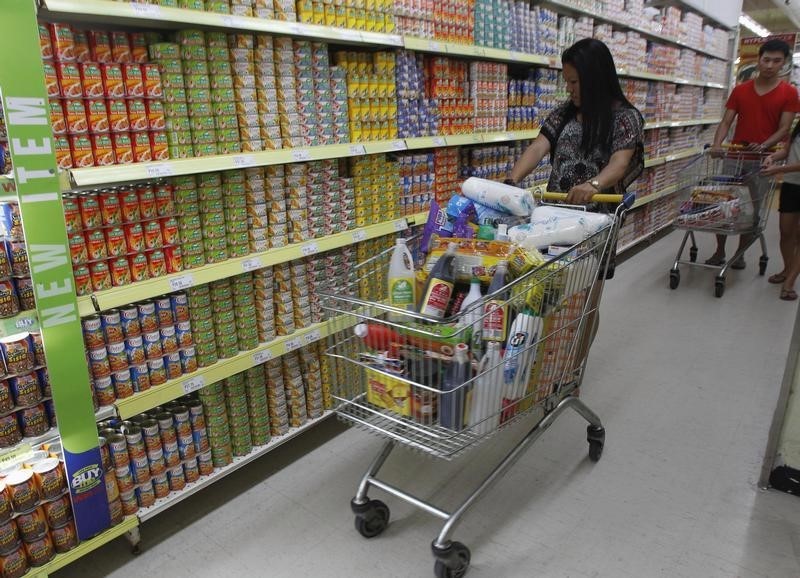 © Reuters. A Filipino shopper pushes a shopping trolley full of food items inside a supermarket in Manila