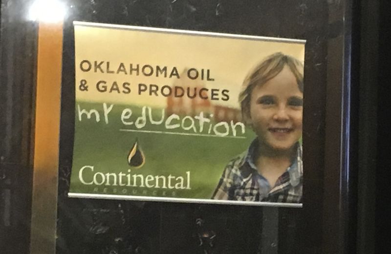 © Reuters. A poster hanging in the lobby of Continental ResourceÕs headquarters features a picture of a young boy and reading ÔOklahoma oil & gas produces my education