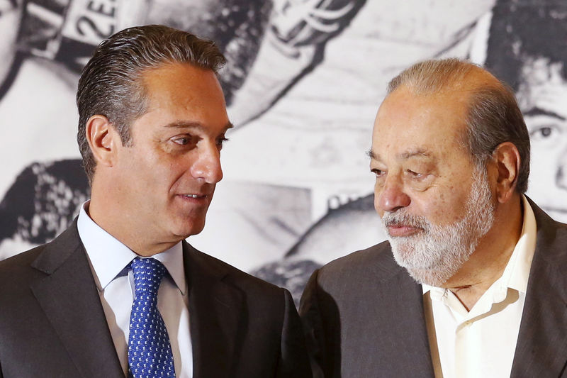 © Reuters. Mexican tycoon Carlos Slim Helu speaks with his son and Chairman of the Board of Directors of Grupo Carso, Carlos Slim Domit, before receiving a recognition from WBC for his support for boxing via Telmex foundation at Soumaya museum, in Mexico City