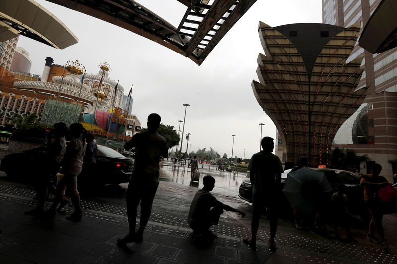 © Reuters. Visitors from mainland China wait outside a casino in Macau