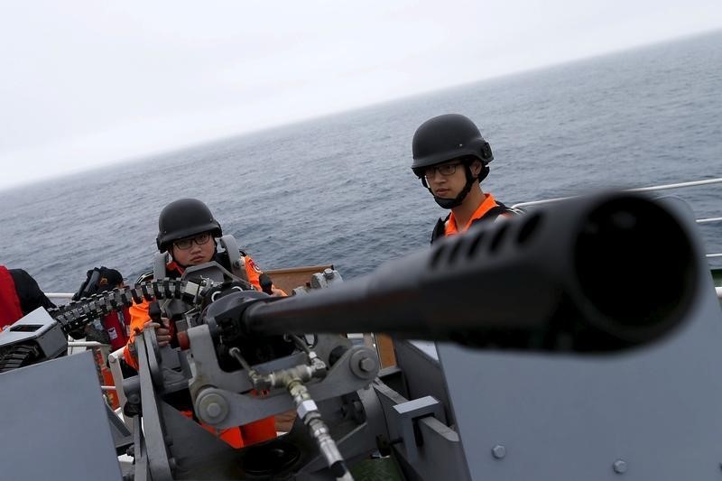 © Reuters. Taiwanese Coast Guard Administration guard demonstrate a machine gun on the docks of the 3000-ton "Ilan" patrol ship at East China Sea, near Pengjia Islet, the northern most island controlled by Taiwan