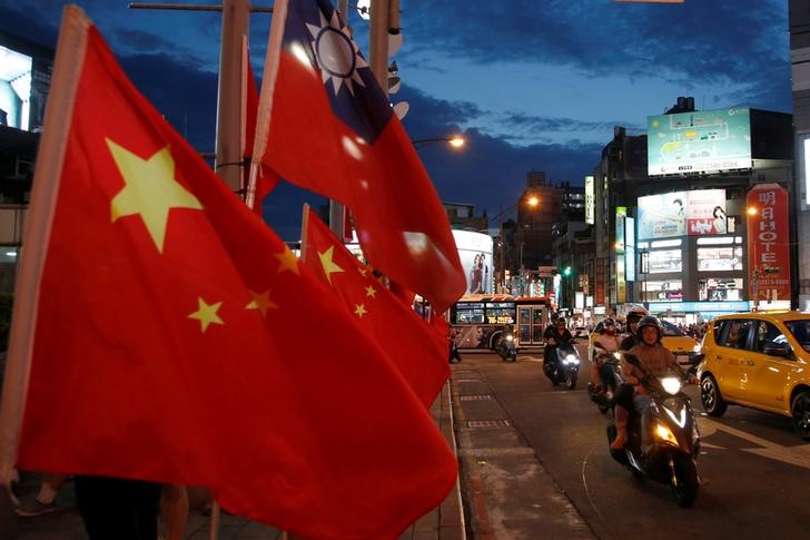 © Reuters. Flags of China and Taiwan flutter next to each other during a rally calling for peaceful reunification, days before the inauguration ceremony of President-elect Tsai Ing-wen, in Taipei
