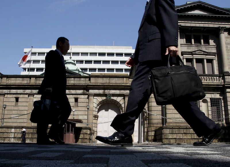 © Reuters. People walk on a street in front of the Bank of Japan headquarters in Tokyo