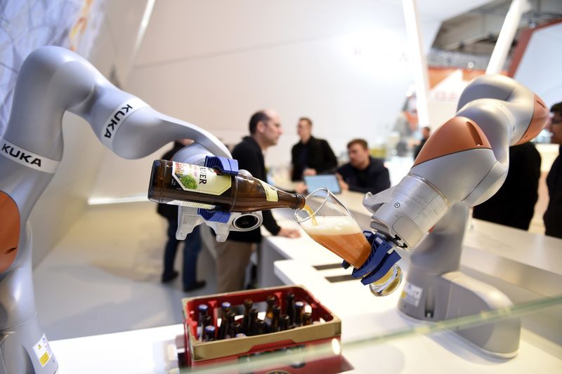 © Reuters. Robots in the Kuka stand pour a beer into a glass at the Hannover Messe industrial trade fair in Hanover