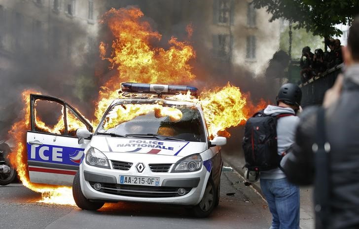 © Reuters. حشد غاضب يحاصر سيارة للشرطة الفرنسية ويضرم النيران فيها