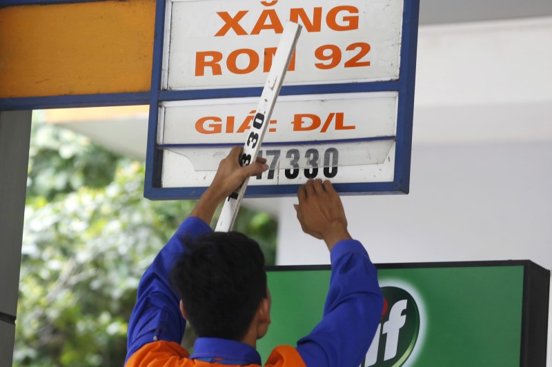 © Reuters. An employee changes a price sign at a petrol station in Hanoi