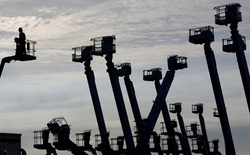 © Reuters. Worker stands on a crane which is parked at a construction site at Keihin industrial zone in Kawasaki