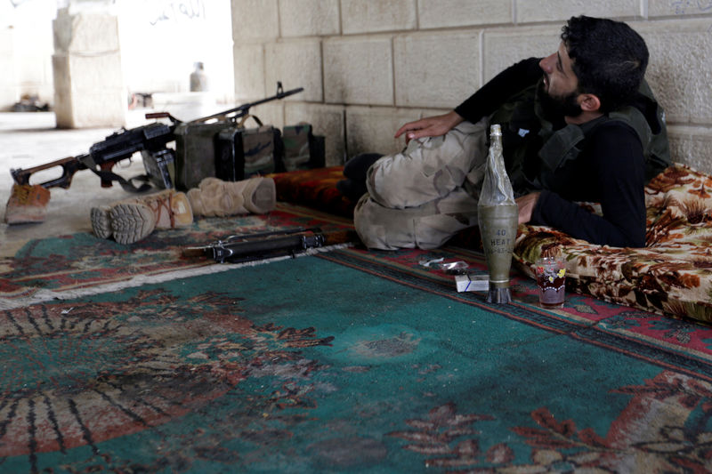 © Reuters. A rebel fighter from Jaysh al-Sunna, operating under a coalition of rebel groups called Jaish al-Fatah, or the army of conquest, rests in Aziziyah village, southern Aleppo countryside