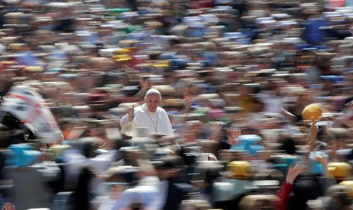 © Reuters. Pope Francis gives the thumb up as he arrives to lead the weekly audience in Saint Peter's Square at the Vatican