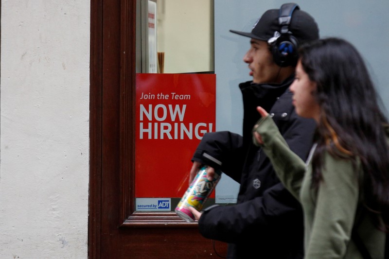 © Reuters. People walk past a "Now Hiring" sign in Manhattan in New York