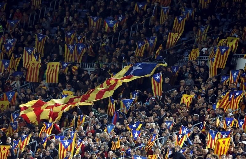 © Reuters. People raise "Estelada" flags (Catalan separatist flag) before Champions League group E soccer match between Barcelona and Bate Borisov in Barcelona