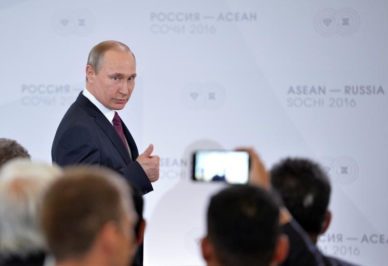 © Reuters. Russian President Putin gestures as he arrives for meeting with businessmen on sidelines of Russia-ASEAN summit in Sochi