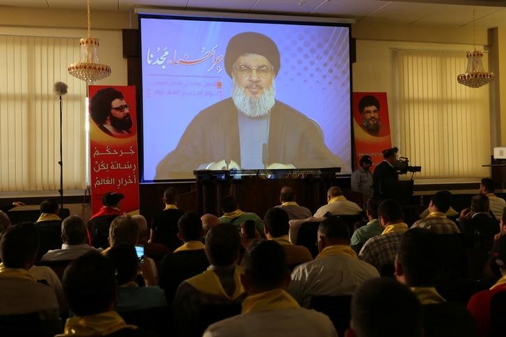 © Reuters. Lebanon's Hezbollah leader Sayyed Hassan Nasrallah addresses his supporters from a screen during a rally to commemorate Hezbollah Wounded Veterans Day in Beirut's southern suburbs