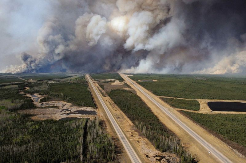 © Reuters. An aerial view of Highway 63 south of Fort McMurray, Alberta. Canada, shows smoke from the wildfires