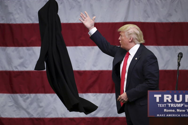 © Reuters. U.S. Republican presidential candidate Donald Trump tosses off his overcoat as he speaks at a campaign event in an airplane hangar in Rome, New York