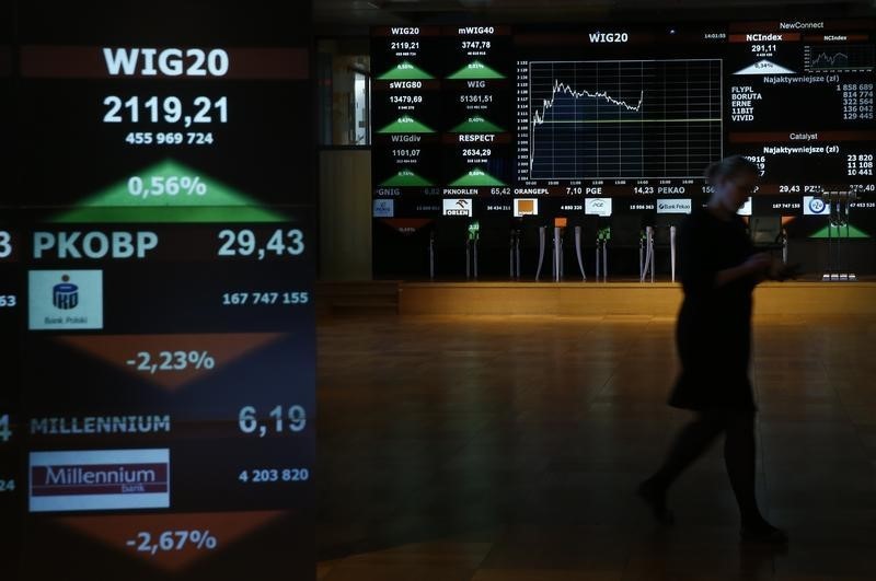 © Reuters. A woman passes by stock exchange display panels in Warsaw