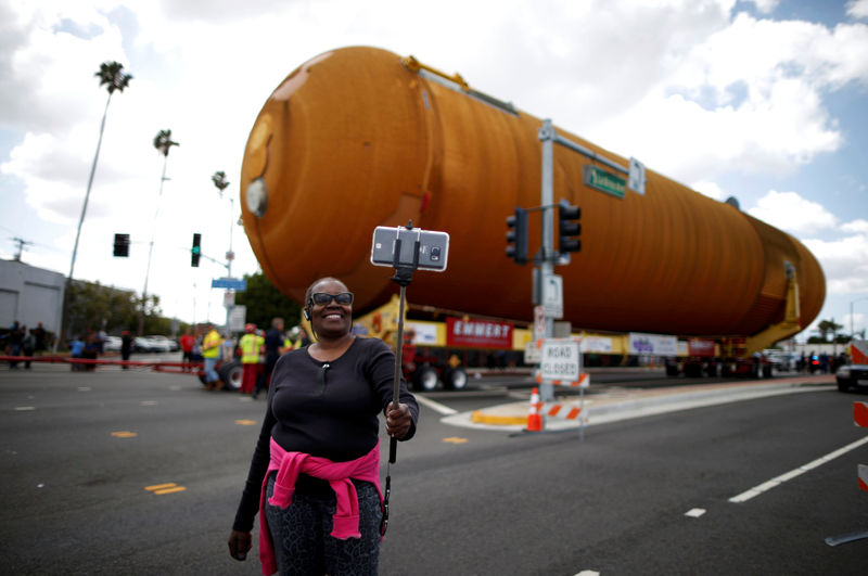 © Reuters. Eddye Chapman takes a picture of herself as the space shuttle Endeavour's external fuel tank ET-94 makes its way to the California Science Center in Exposition Park in Los Angeles, California