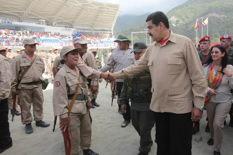 © Reuters. Venezuela's President Nicolas Maduro shakes hands with a militia member during a military parade in La Guaira