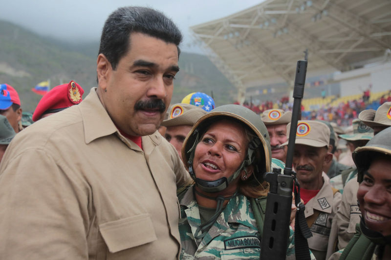 © Reuters. Venezuela's President Nicolas Maduro poses for a photo with a militia member during a military parade in La Guaira