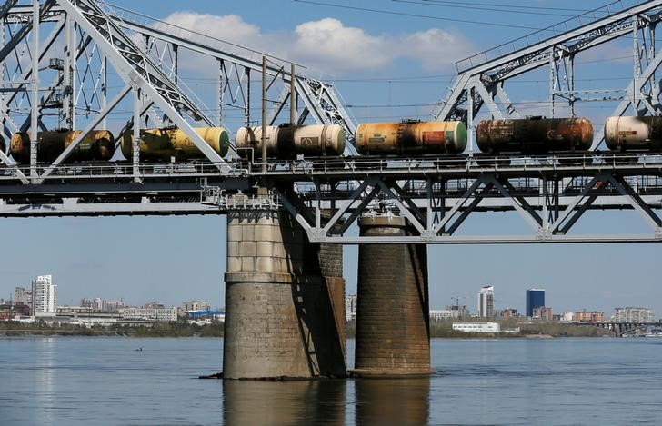 © Reuters. Поезд, состоящий из нефтяных цистерн, пресекает мост Транссибирской магистрали через Енисей