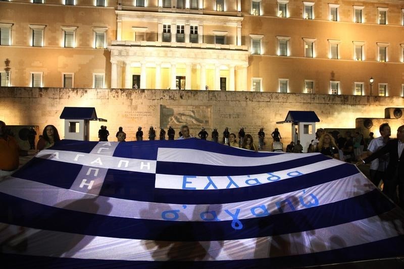 © Reuters. Demonstrators display the Greek flag in front of parliament in Athens