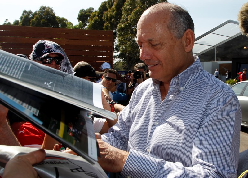 © Reuters. Chairman and CEO of McLaren Formula One team Dennis signs autographs at the first practice session of the Australian F1 Grand Prix in Melbourne