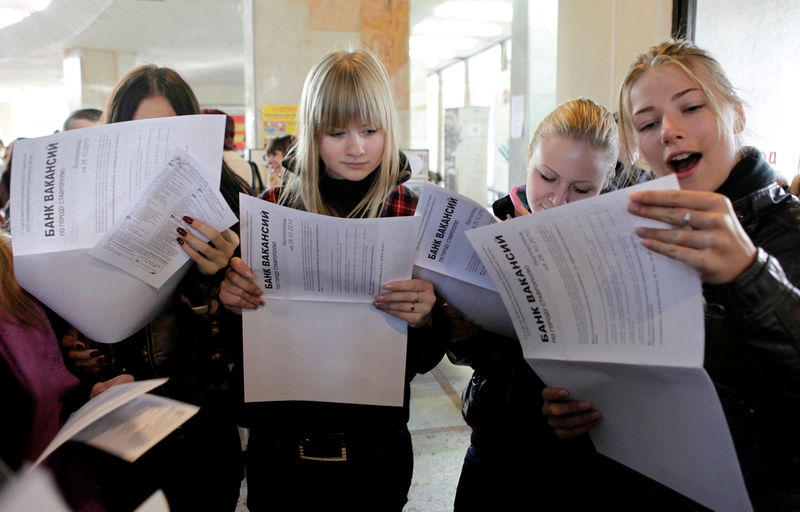© Reuters. Women look at job listings during a city job fair held in the southern city of Stavropol