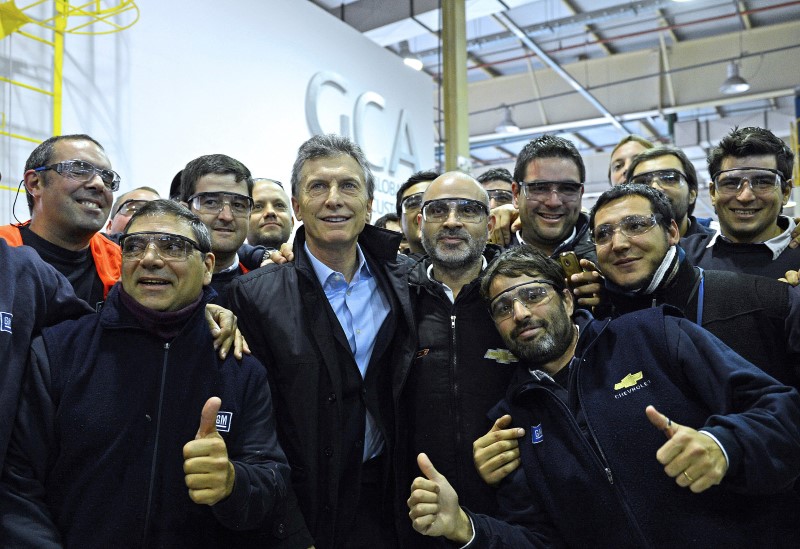 © Reuters. Macri posa com trabalhadores em fábrica da General Motors perto de Rosário